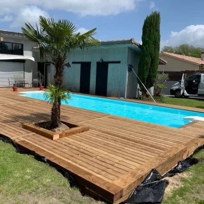 Nouvelle installation d'une terrasse en pin par O2bois, intégrant nature et confort autour d'une piscine, chez un client à Royan.